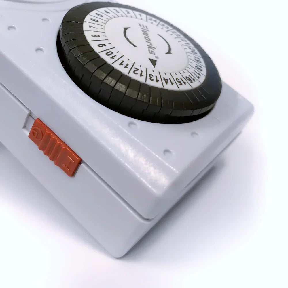 Nærbillede af en hvid LYNEL mini timer døgnur med sort drejeskive og orange kontakt.