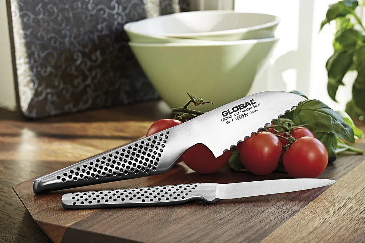 GLOBAL tomatkniv GS-9 i rustfrit stål sammen med friske tomater på et skærebræt.