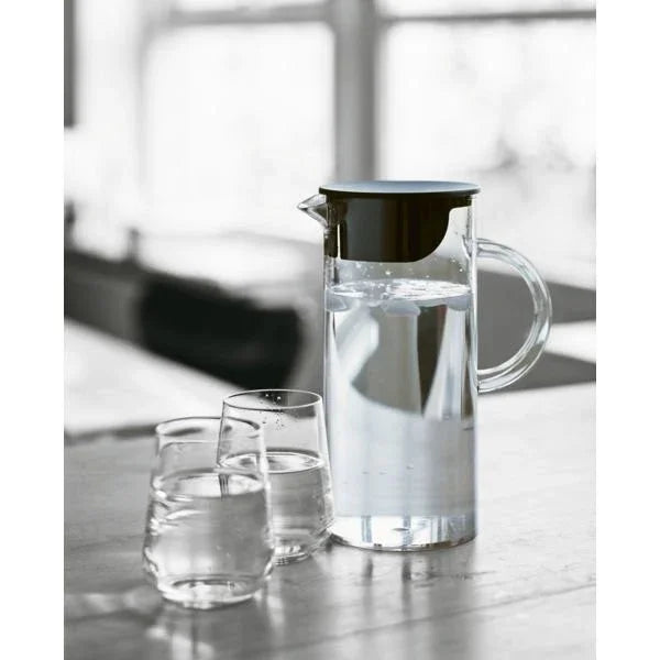 STELTON EM77 juicekande i glas med sort låg og to matchende glas på et bord