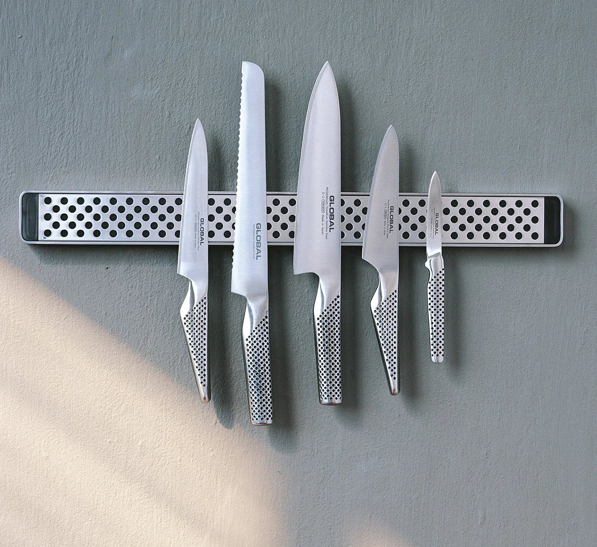 Sæt af GLOBAL køkkenknive i forskellige størrelser på en magnetisk knivskinne