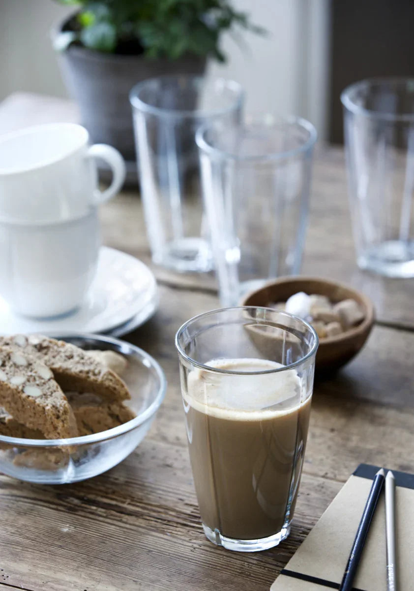 Rosendahl Grand Cru latteglas med kaffe på et rustikt træbord ved siden af biscotti